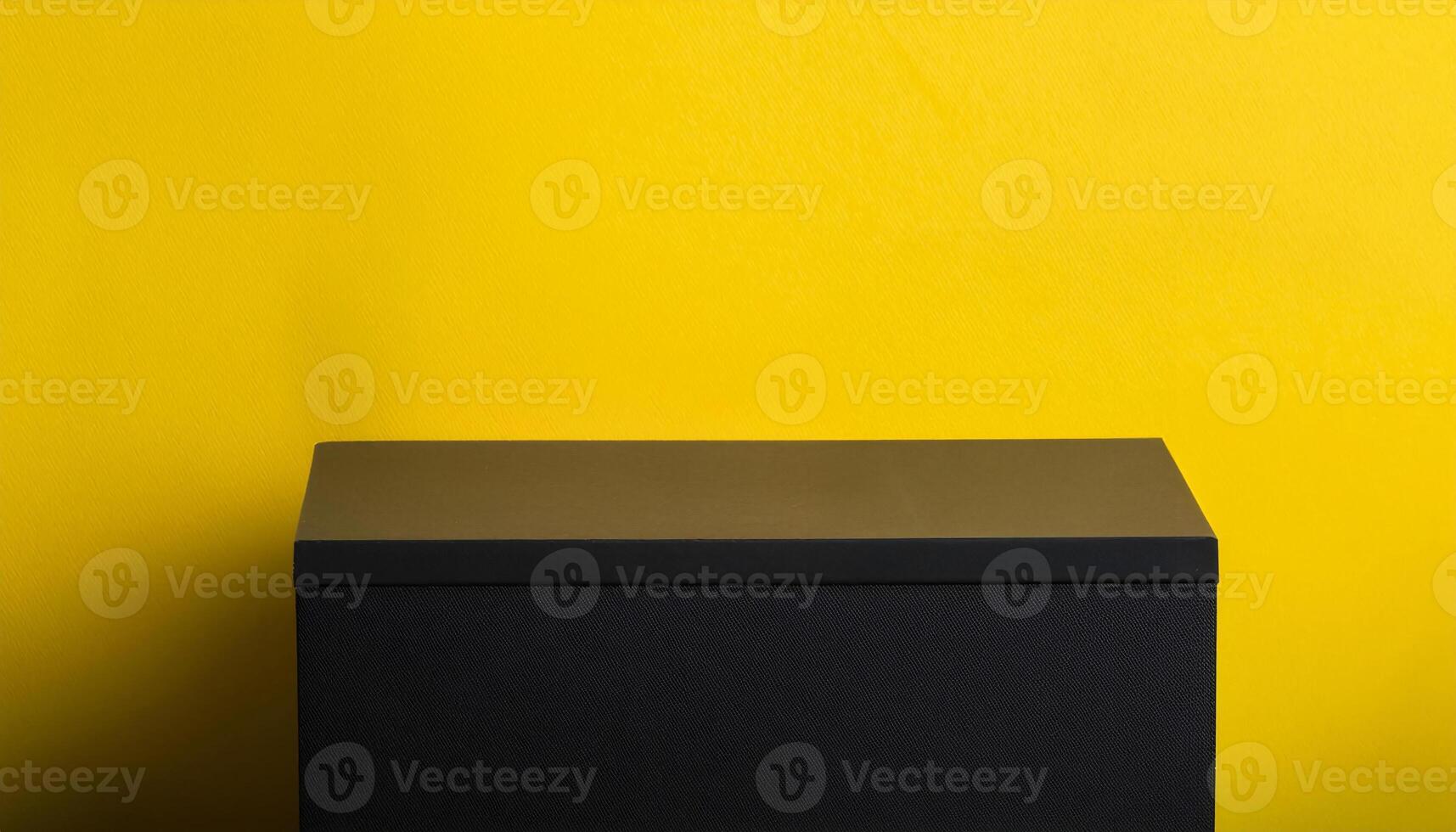 modern black table with a bold yellow background for playful and vibrant product presentations photo