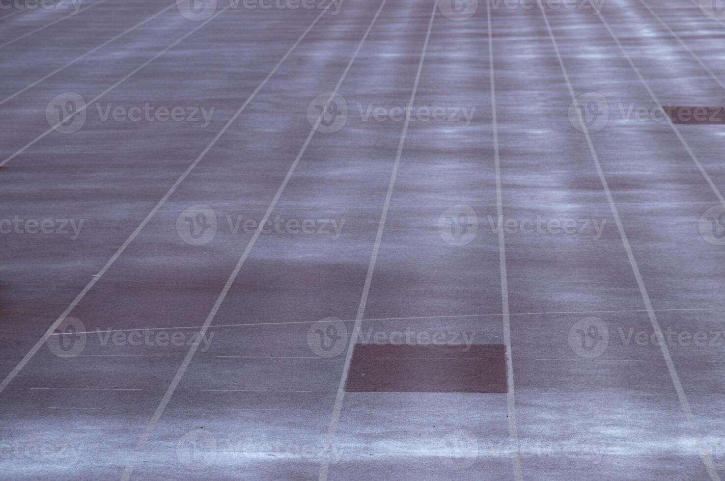 Empty parking lot showing white lines and one dark spot photo