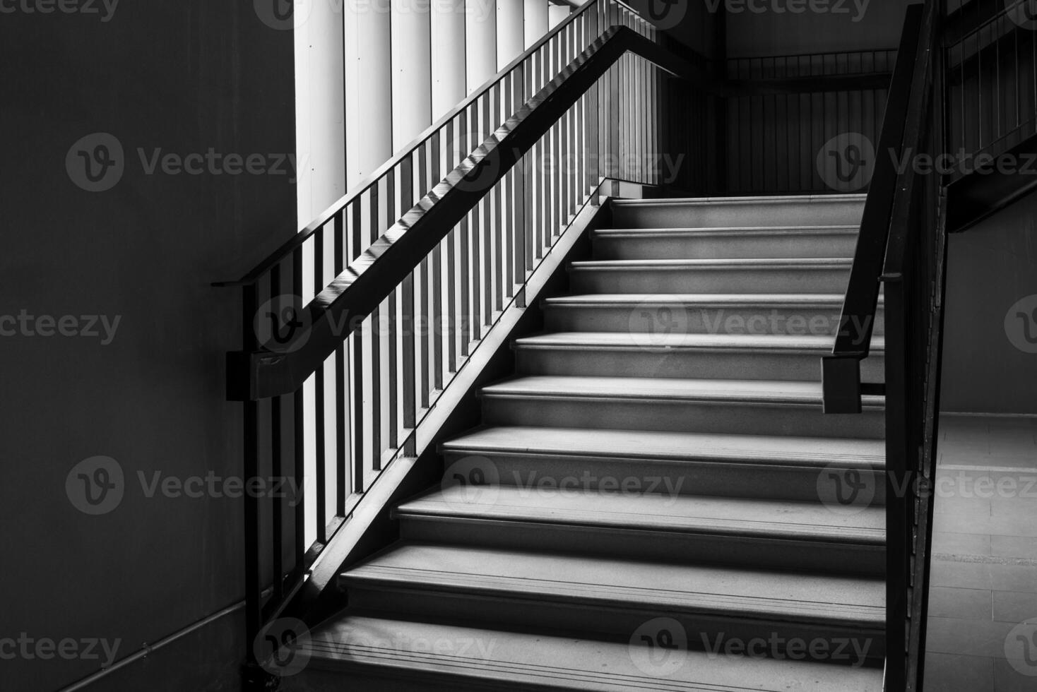 Empty Modern Concrete Staircase and black steel handrail with natural light, staircase in modern building - Dark Tone photo