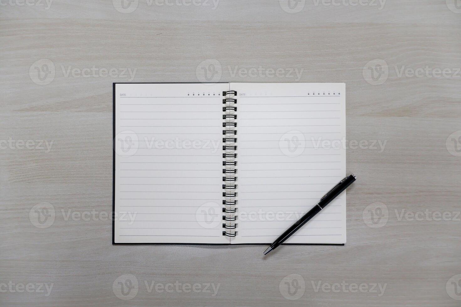 Page lined notebook with pen on wooden table background photo