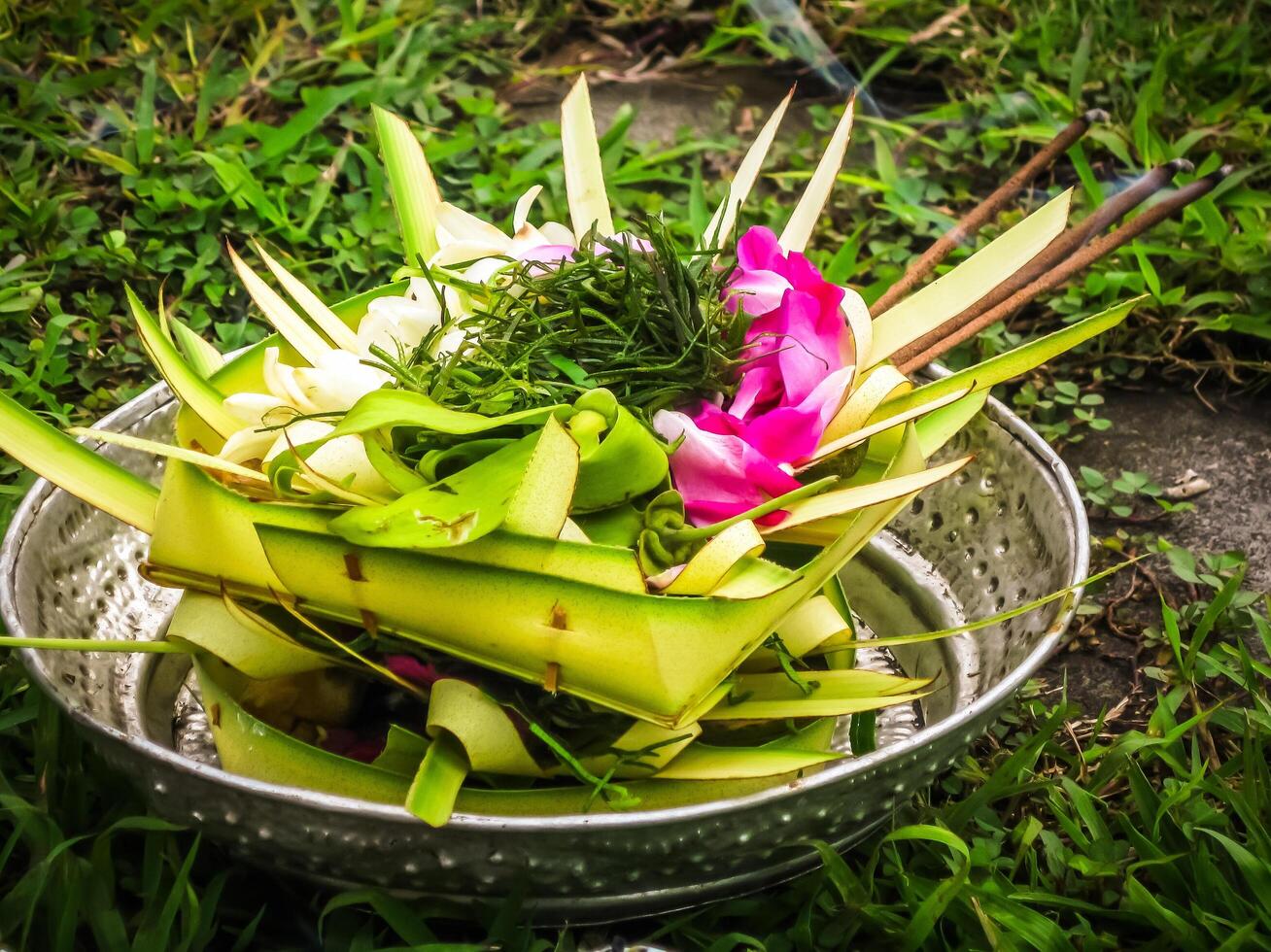 Balinese Hindu offerings, called sesajen, are intricate arrangements of flowers, rice, and other symbolic items presented in woven palm leaf trays photo