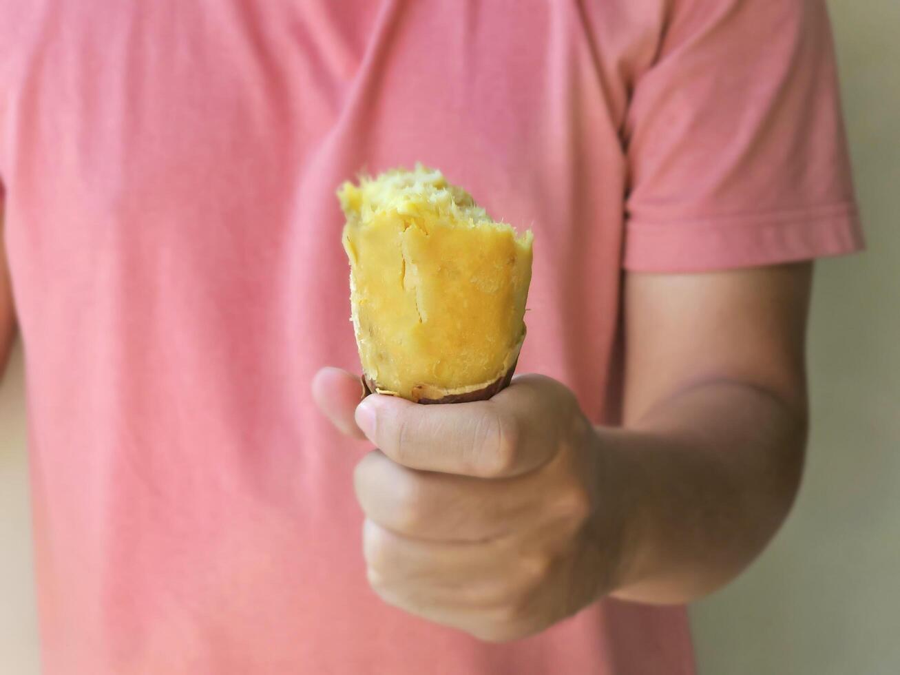 Hand holding Baked peeled Japanese sweet potato Beni Haruka. Healthy food photo