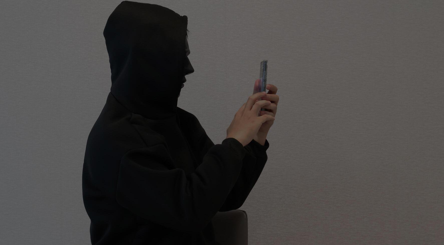 Side view Scammers, masked individuals holding phones, criminal networks stealing information through telephone photo