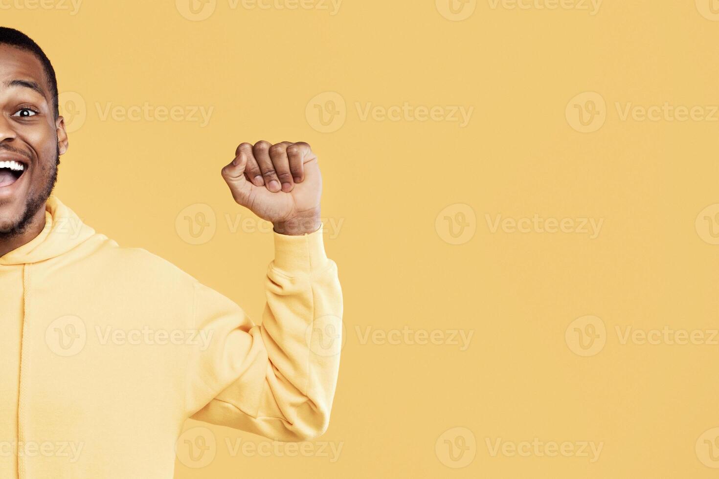 Joyful African American Man Gesturing Yes Smiling To Camera Celebrating Success Posing On Yellow Background. Studio Portrait Of Millennial Guy Expressing Joy Emotion. Victory Celebration. Panorama photo