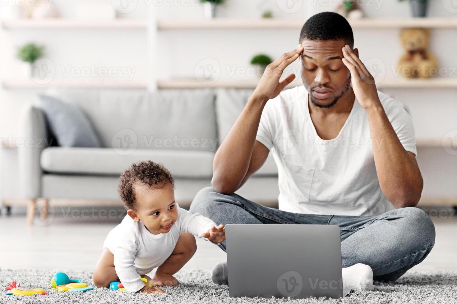 Paternity Leave Stress. Depressed Black Father Having Problems With Remote Work While Babysitting His Little Infant Child, Exhausted African American Man Suffering Headache While Working On Laptop photo