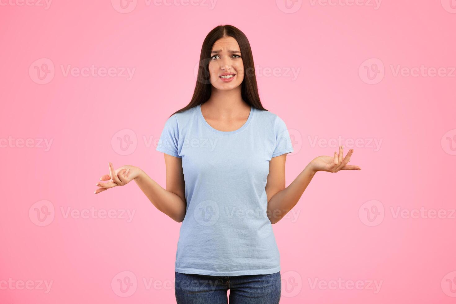 Who Knows. Portrait Of Confused Woman Shrugging Shoulders, Spreading Hands, Looking At Camera Posing Over Yellow Background. Studio Shot. Puzzled lady is clueless. I'm sorry, exuse me, can't decide photo