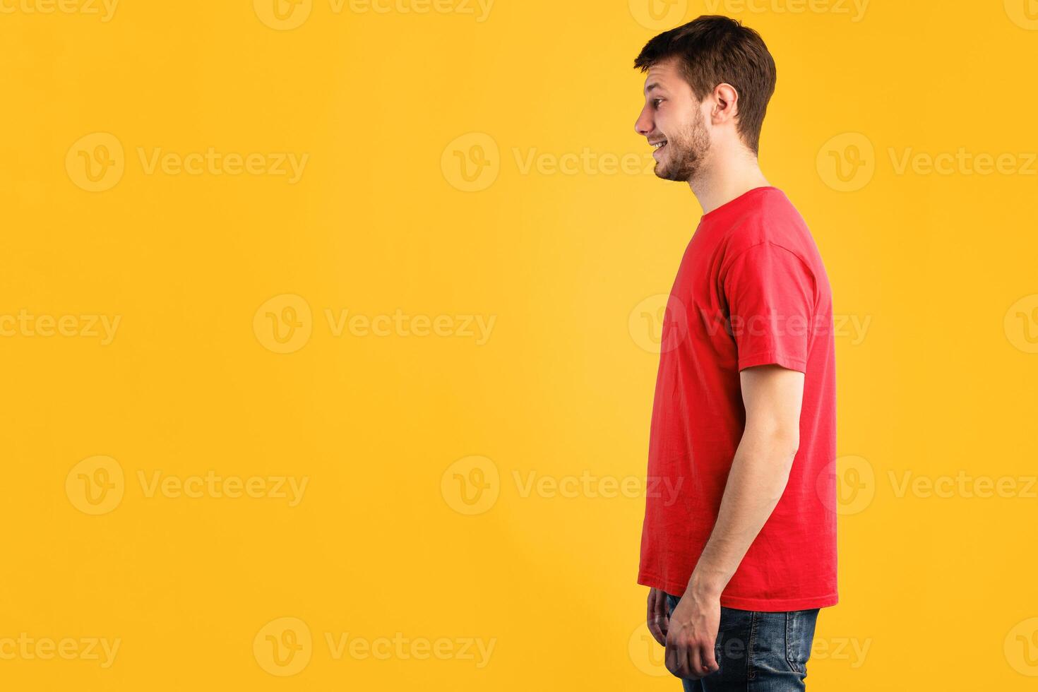 Profile portrait of bearded casual smiling caucasian man posing isolated over blue studio background. Side view of positive guy standing and looking at copy space photo