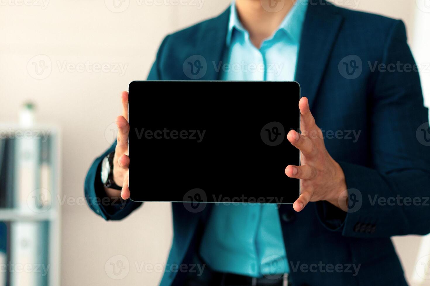 Unrecognizable Arab businessman showing tablet computer with blank screen, offering mockup for website or app at office. Cropped view of millennial employee demonstrating touch pad with copy space photo