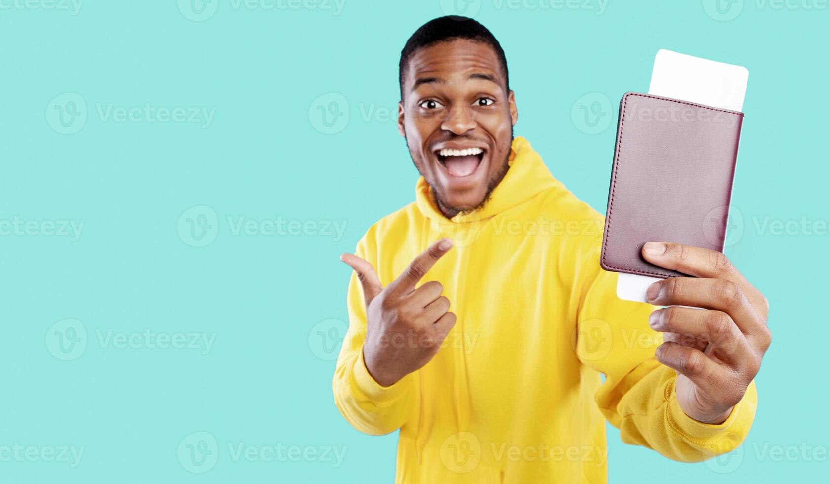 Cheap Flight Tickets. Excited African American Tourist Guy Showing Boarding Pass And Passport Standing Over Blue Studio Background, Smiling To Camera. Travel And Tourism, Vacation Concept photo