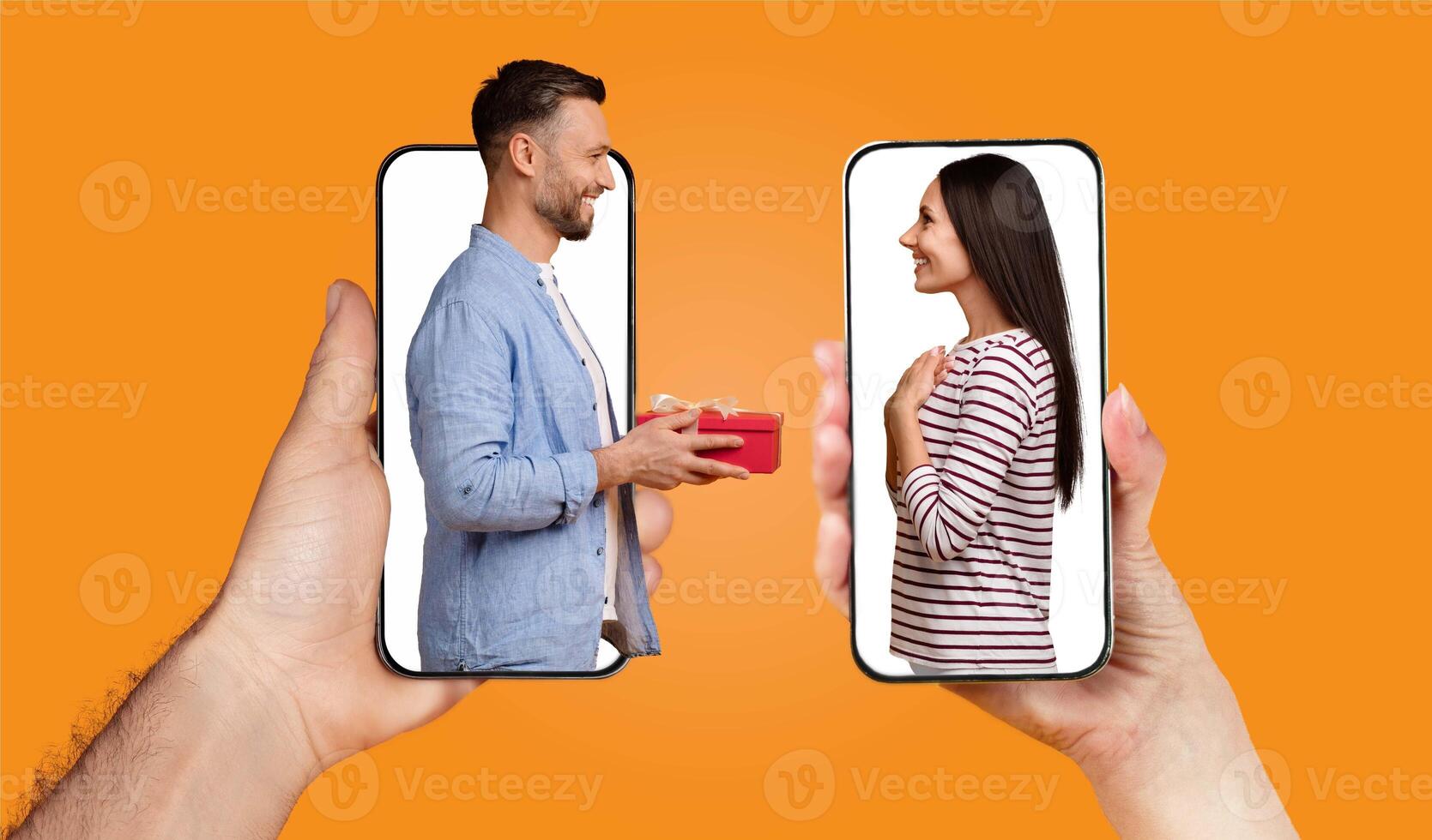 A couple is engaged in a joyful exchange using their smartphones. The man holds a gift while looking at the woman, who is smiling and appreciating the moment. photo