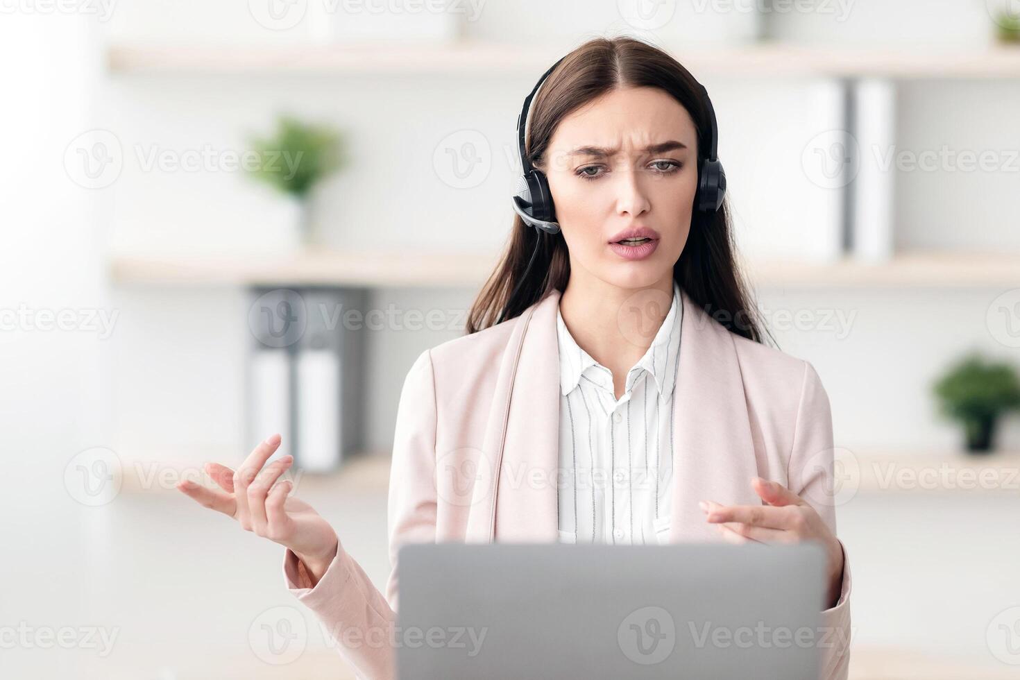 Professional Female Manager Making Call Talking With Client Sitting At Laptop And Solving Customer's Problems In Modern Office, Wearing Headset. Hotline Service Operator, Online Consultation photo
