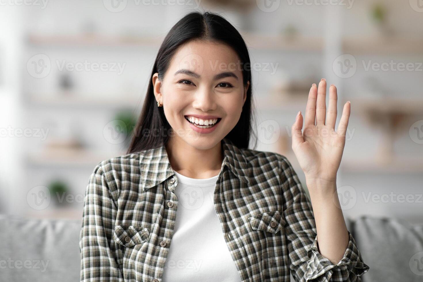 Positive asian lady having online party with boyfriend or family, job interview, using telecommunication application or software at home, cheerfully waving at camera, copy space, pov screen photo