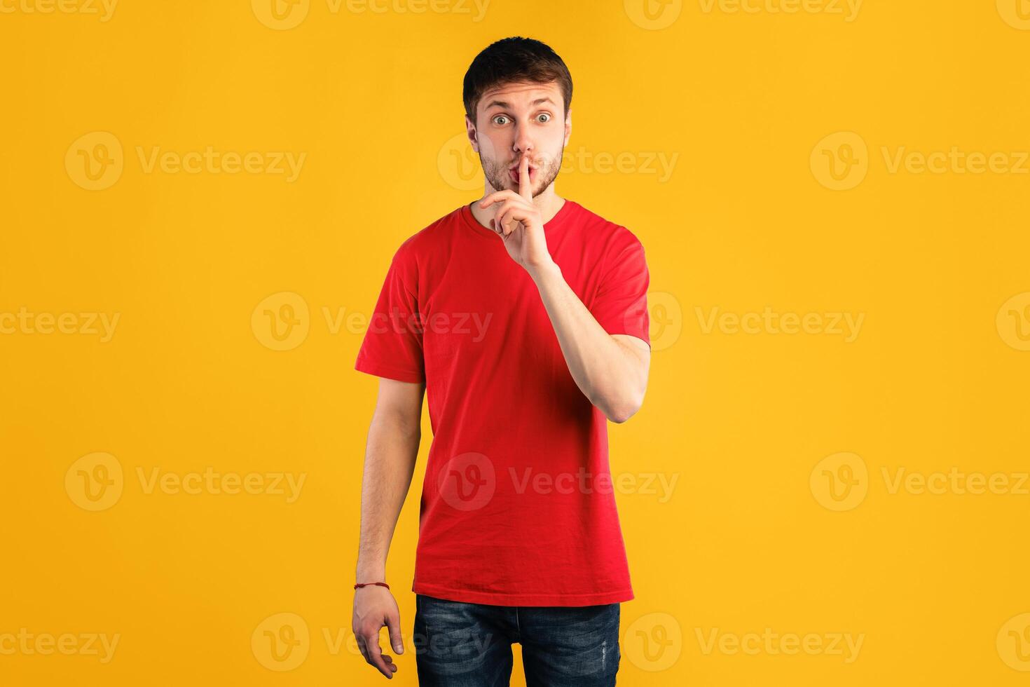 Shh, Keep Silence Concept. Young Man Gesturing Hush Sign Posing Standing Isolated Over Blue Background, Looking At Camera, Studio Shot. Finger On Lips, Silent Gesture, Secret. Copy Space photo