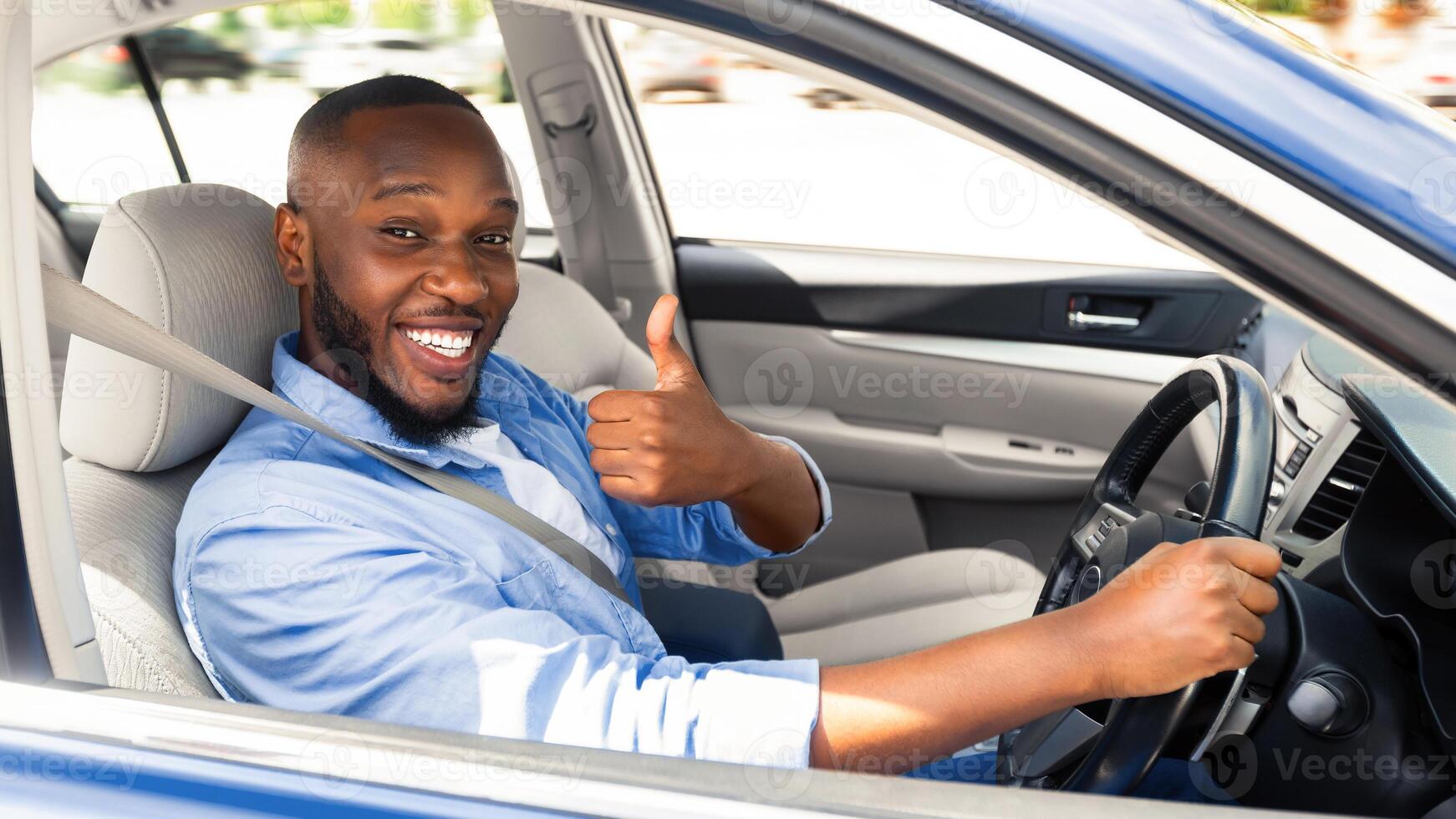 Great Car. Happy African American Man Showing Thumbs Up Sign Gesture, Sitting In New Automobile Buying Modern Vehicle In Dealership Store Or Enjoying Vacation, Looking Out Of Window. Selective Focus photo