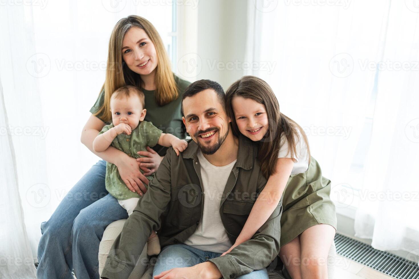 Happy family at home. Mother father two children daughters relaxing indoor. Mom dad parents baby girls kids relax playing having fun together. Family smiling laughing enjoying tender love moment photo