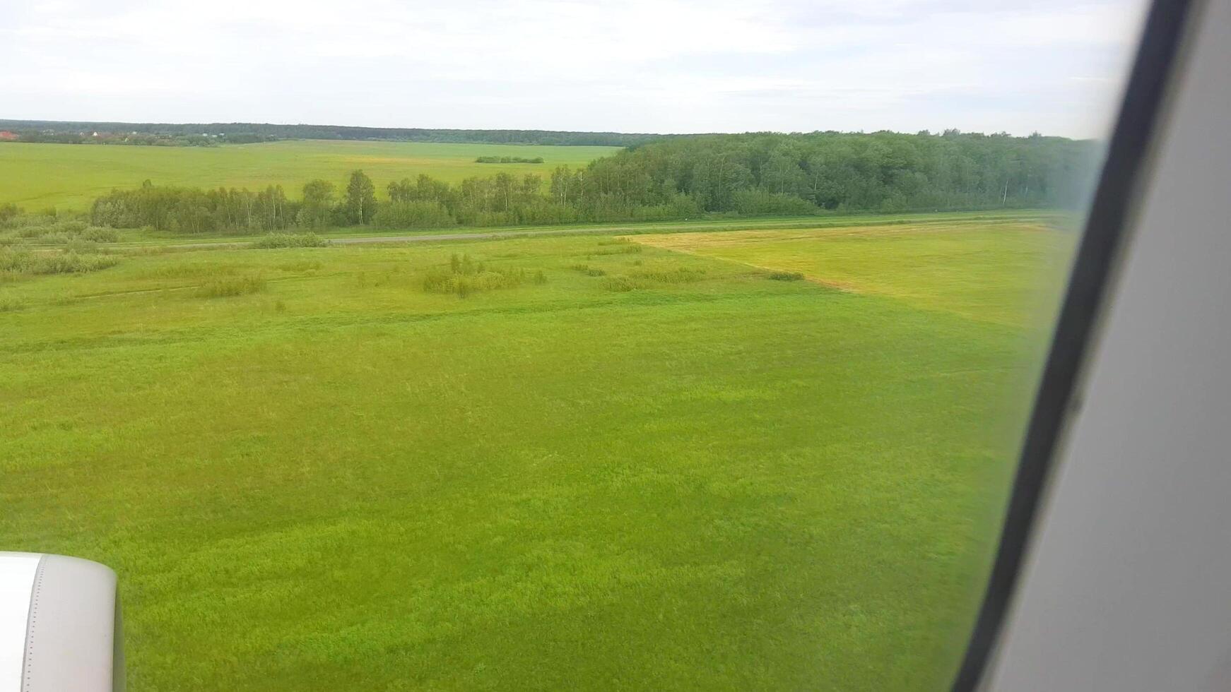 A view of the grassy field from an airplane window photo