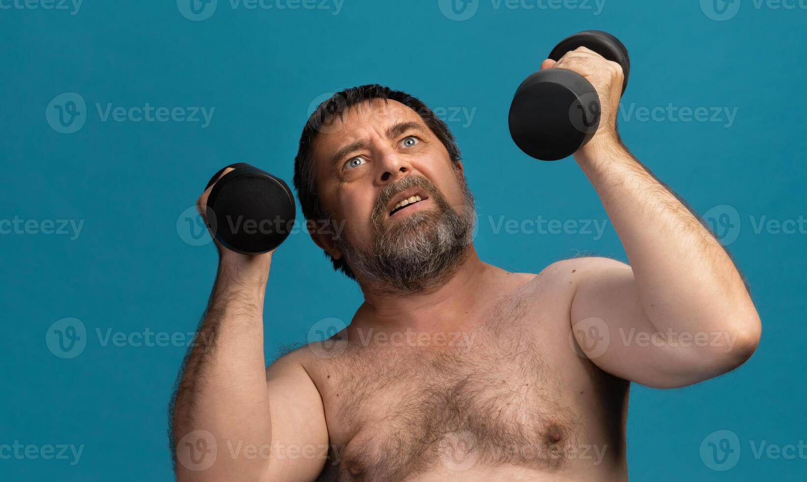Elderly man looks determined while exercising with dumbbells in a bright setting photo