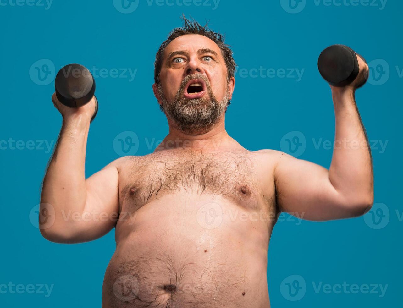 Elderly man lifts dumbbells while exercising indoors during a fitness routine photo