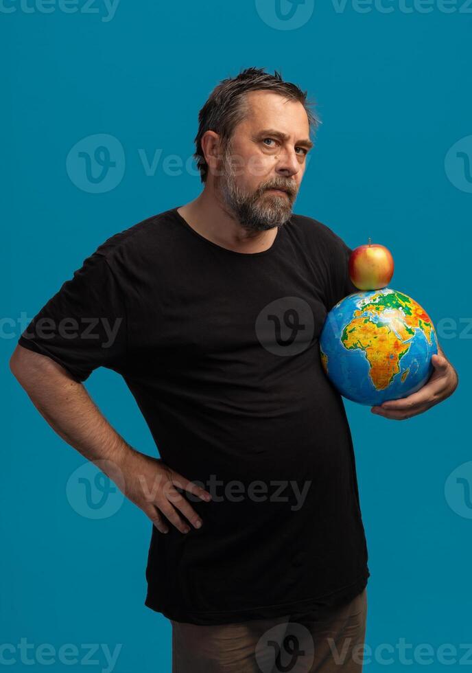 Man holding a globe and apple symbolizes global awareness through a creative perspective photo