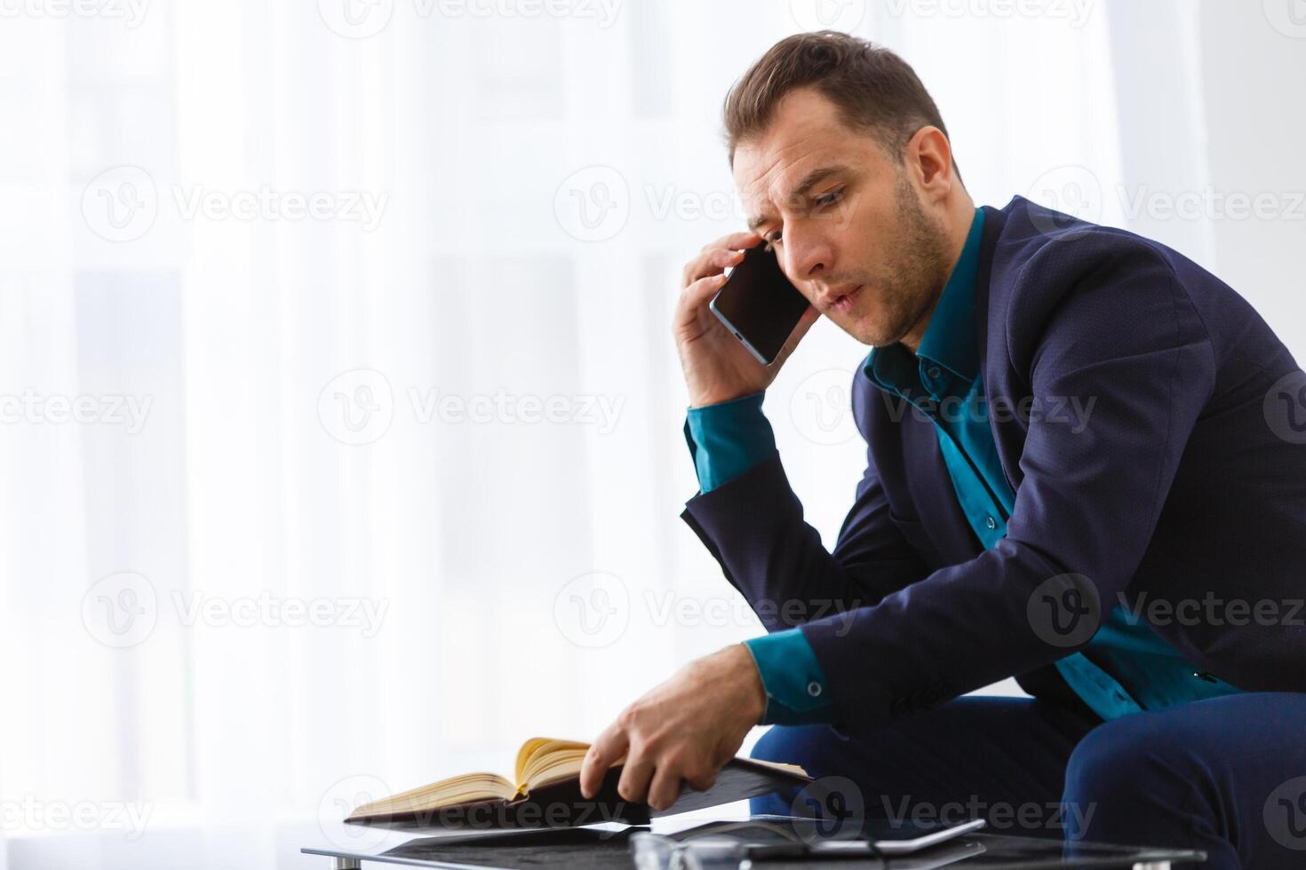 Handsome young man working while sitting on the couch in office photo