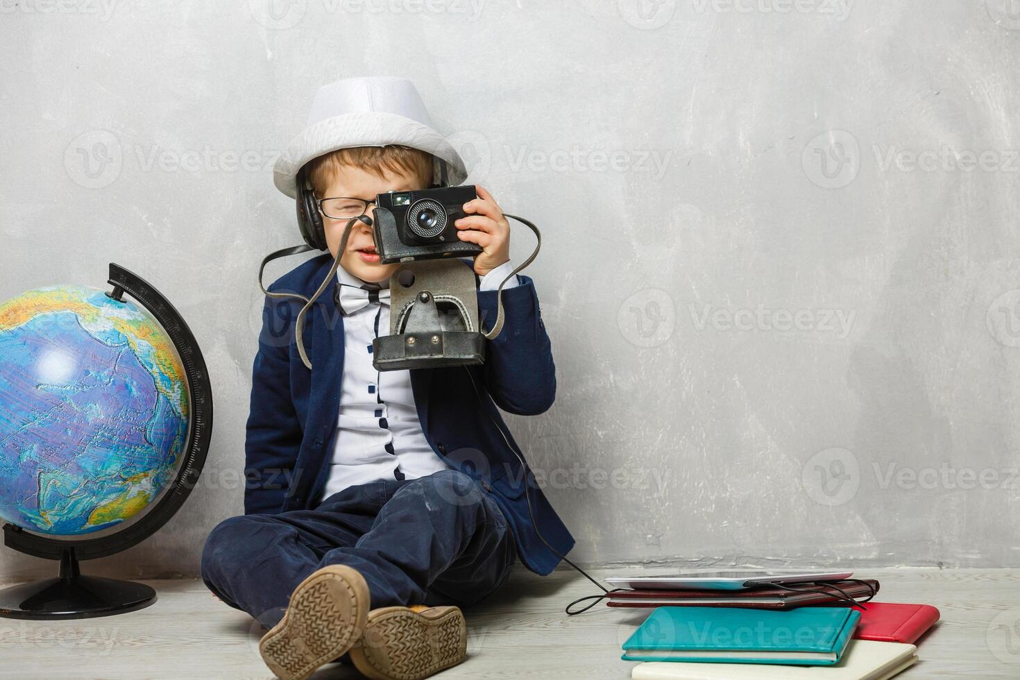 little photographer, boy with camera, stylishly dressed child in a waistcoat with a tie takes pictures on a digital camera photo