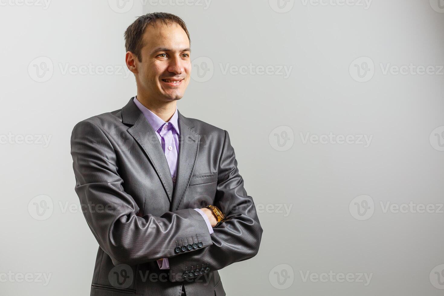 Cool businessman standing on grey background. photo