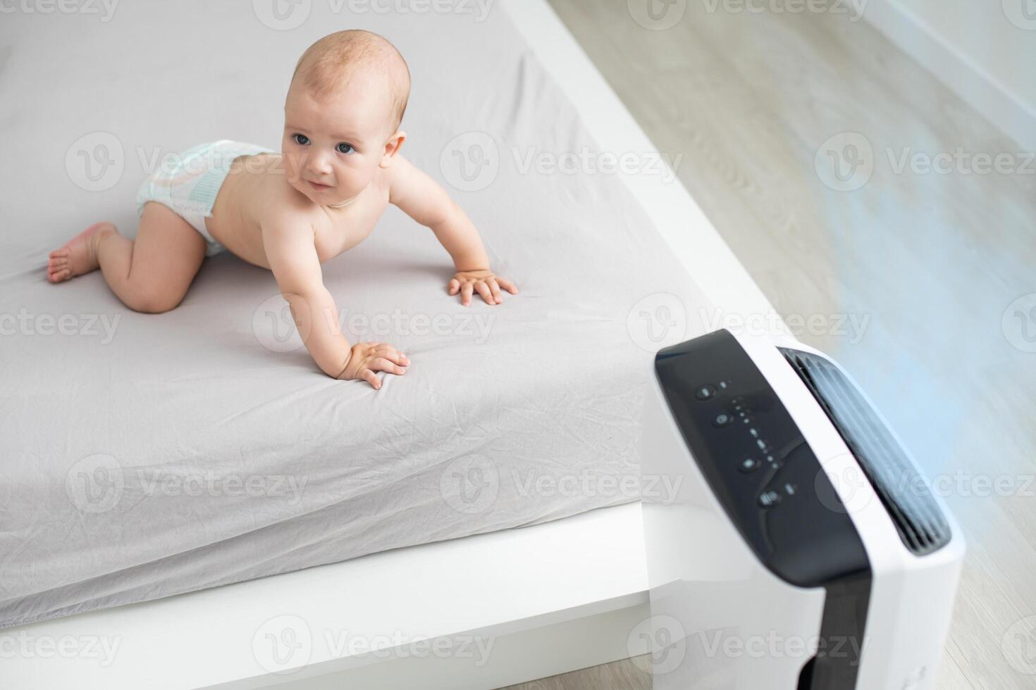 baby near air purifier at home. photo