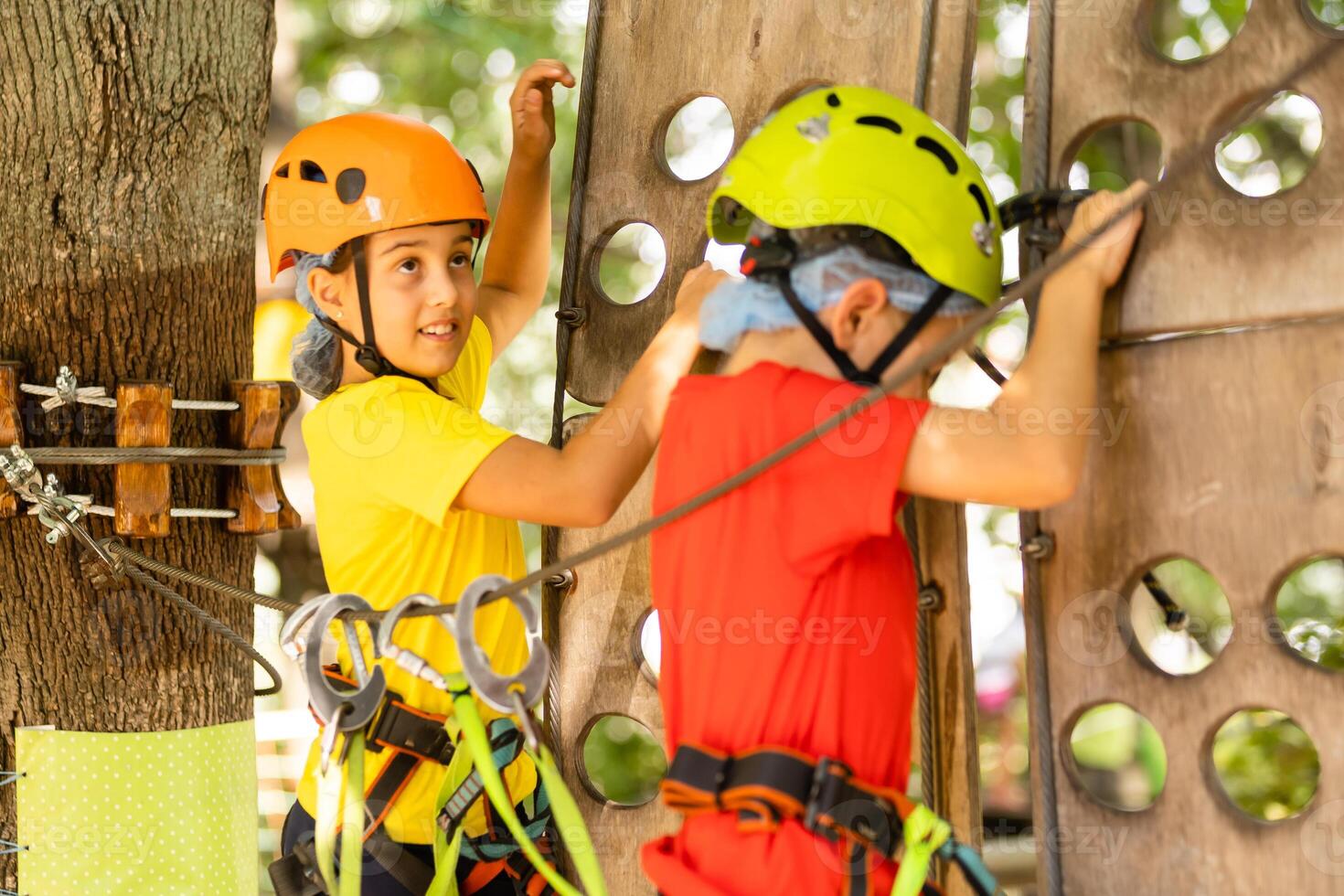 Cute children. Boy and girl climbing in a rope playground structure at adventure park photo
