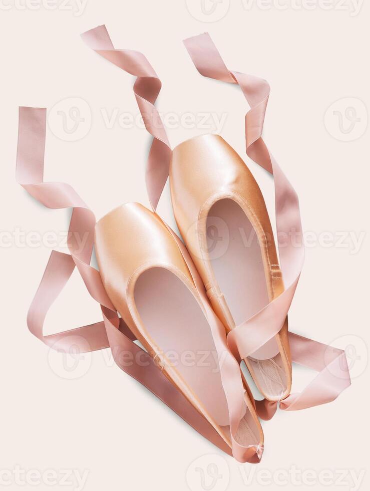 Pastel pink ballet shoes background. New pointe shoes with satin ribbon lay on white isolated backdrop photo