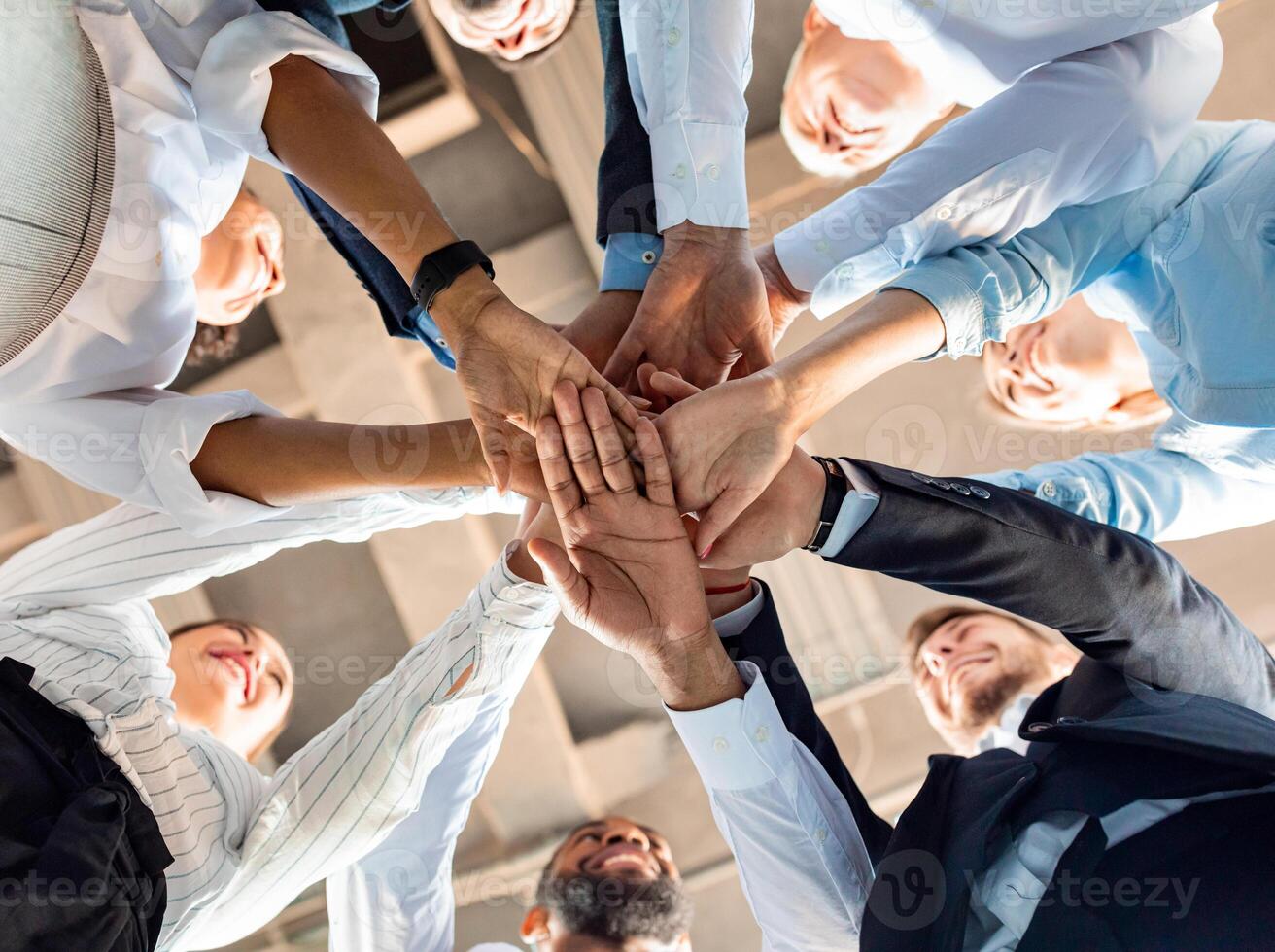 Business Unity And Teambuilding. United Colleagues Standing In Circle Holding Hands Together In Modern Office. Bottom View photo