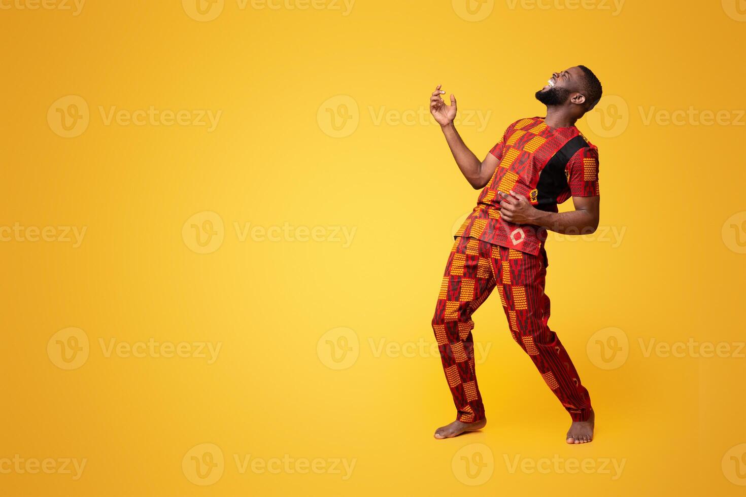 Joyful african american young man fooling over yellow background, playing on imaginary guitar photo