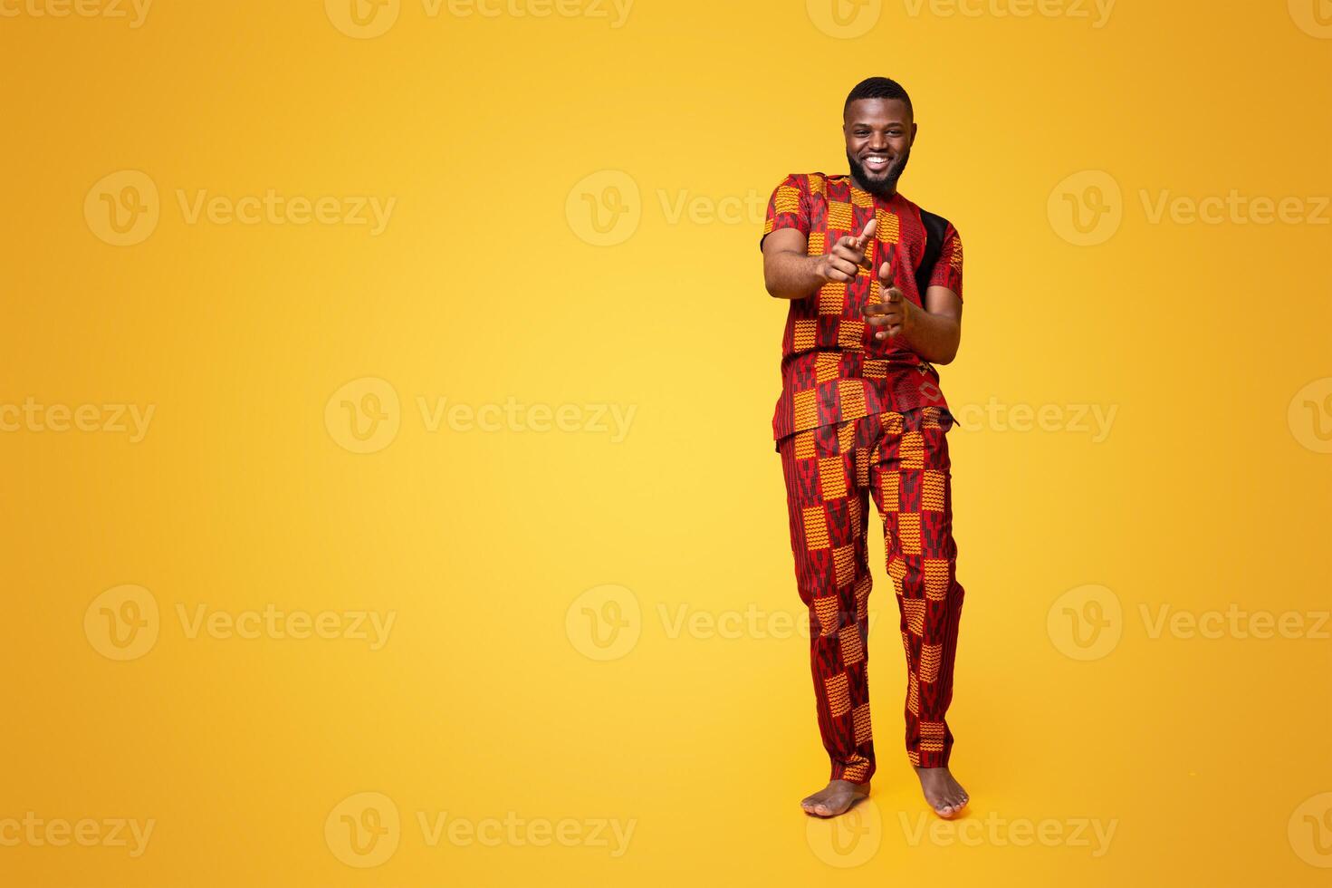Handsome cheerful black guy in authentic clothes flirting over yellow studio background photo