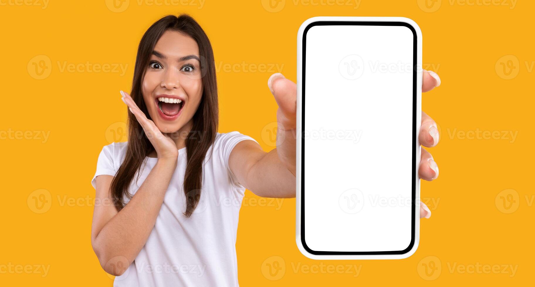 Wow, Amazing Useful App. Portrait of excited and surprised young woman holding smartphone with black blank screen in hand, showing device, closeup. Gadget with empty free space for mock up template photo