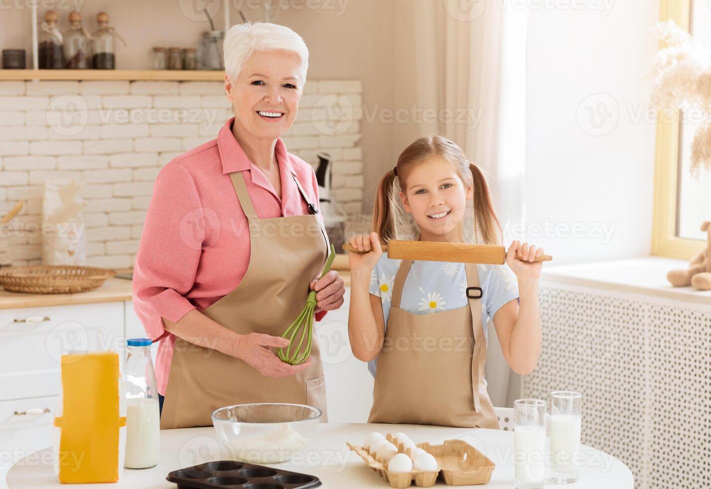 Family cooking. Happy retired lady and cute little girl baking together in kitchen photo