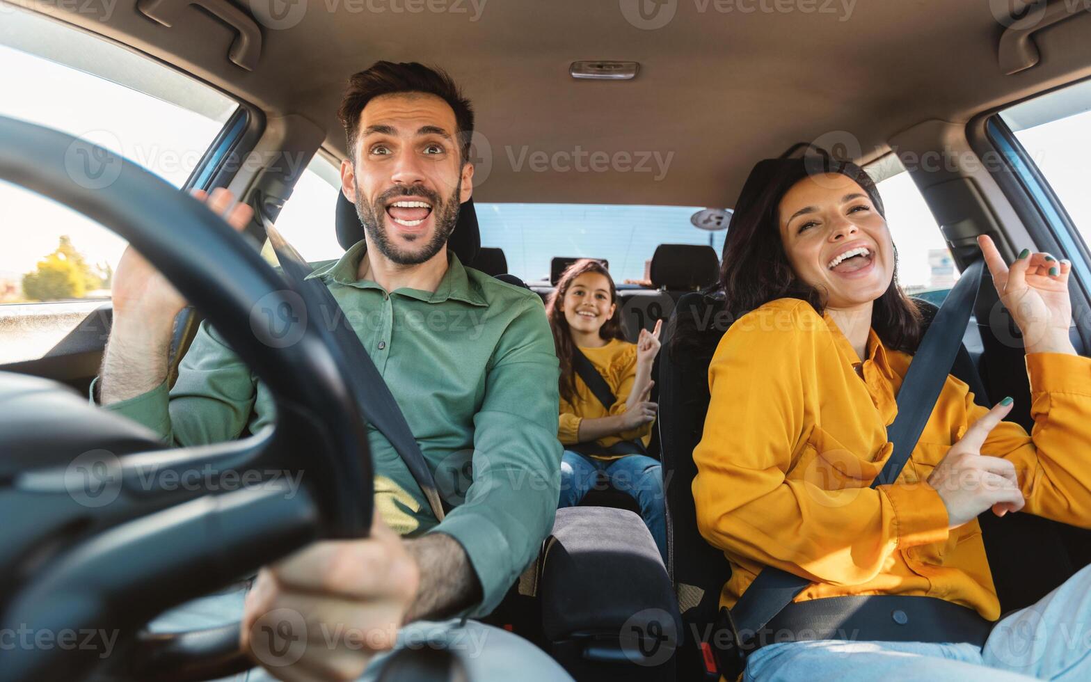 We are going on vacation. Happy family of three driving in their automobile, dancing to music and singing favorite song, enjoying travelling by car photo