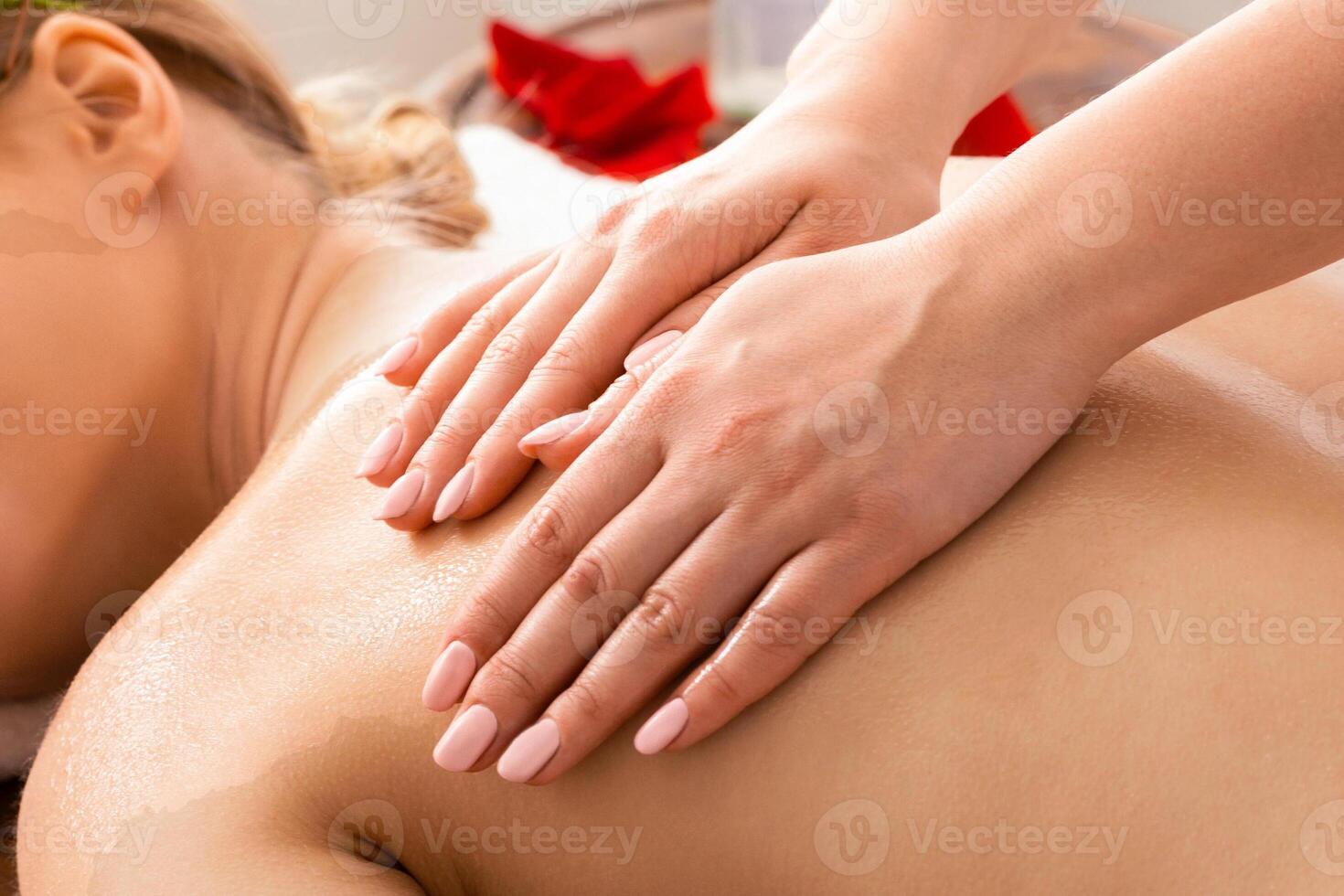Portrait of relax young lady receiving massage in spa salon photo