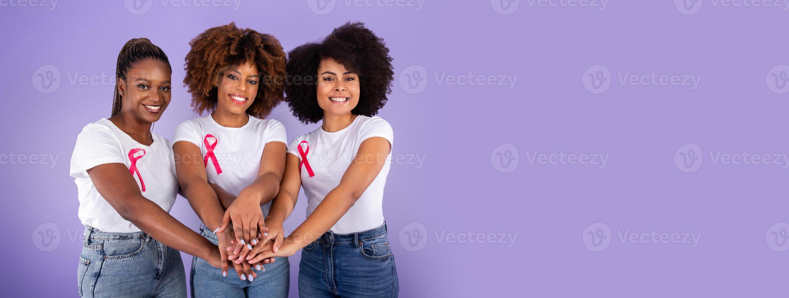 Breast Cancer Awareness. Three Smiling Black Ladies With Pink Ribbons Joining Hands In Stack Over Purple Studio Background. Fighting Oncology Together Concept, Support Group photo