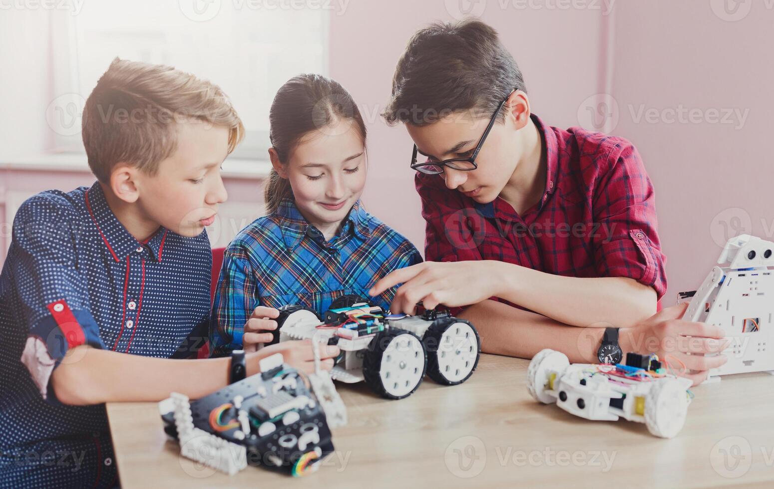 Children creating robots at school, stem education, copy space. Early development, diy, innovation, modern technology concept photo