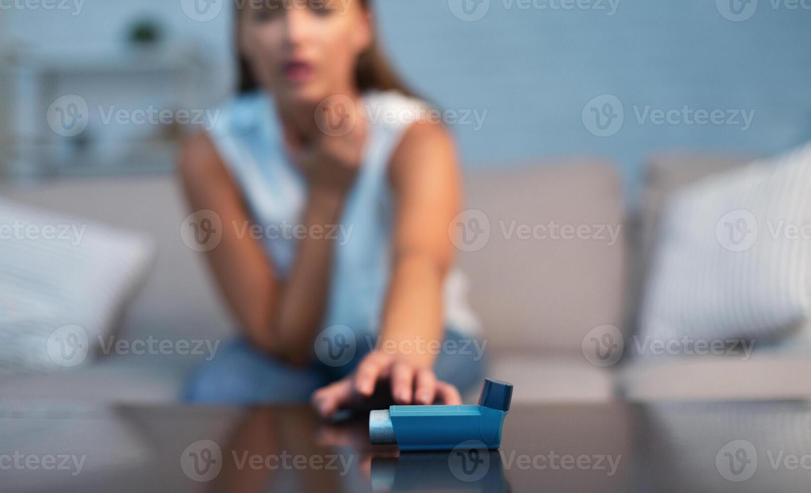 Unrecognizable Girl Reaching For Asthma Inhaler Preventing Attack Sitting On Sofa Indoor. Selective Focus, Shallow Depth photo