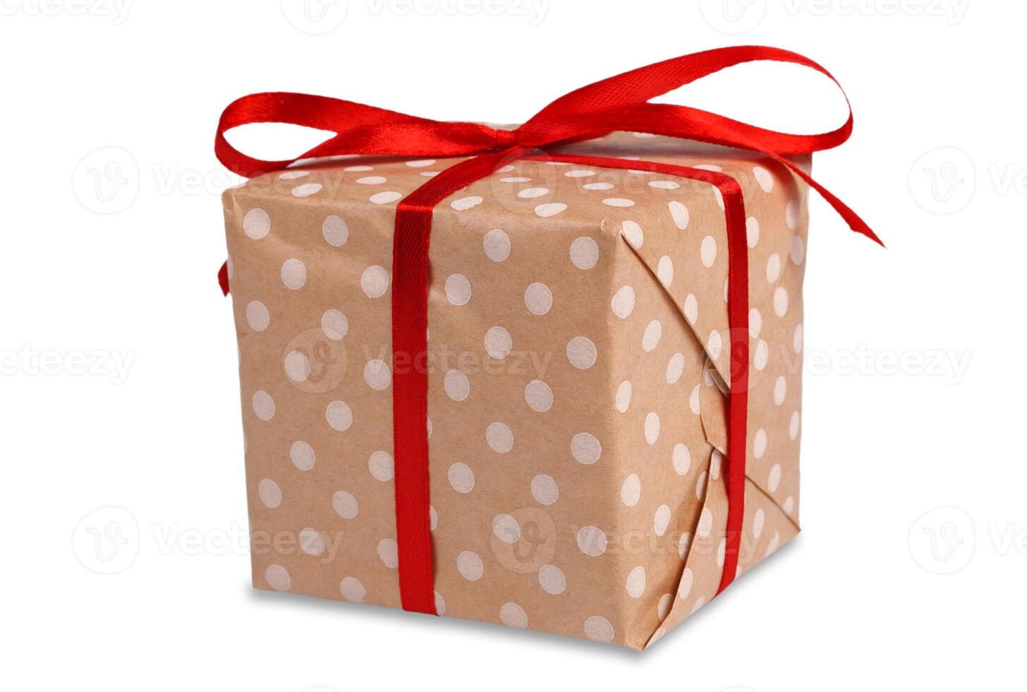 Gift box wrapped with dotted paper and red satin ribbon, isolated on white background. Modern present for any holiday, christmas, valentine or birthday photo