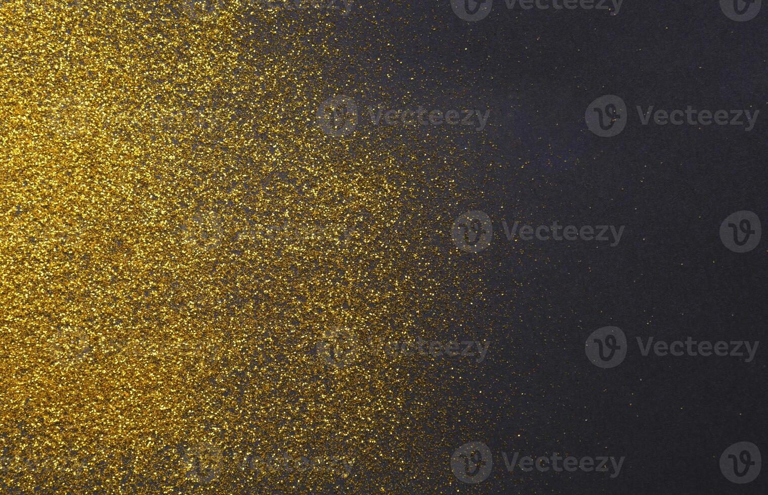 Golden glitter sand texture on black, abstract background. Yellow dusty shimmer decoration, shiny and sparkling frame, top view,copy space. Holidays and glamour concept. photo