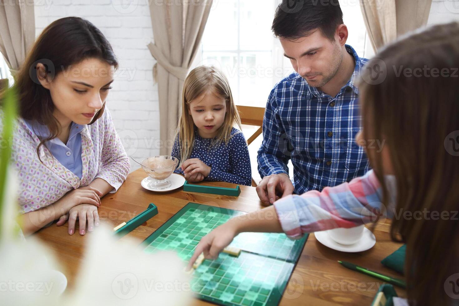 Happy young family plaing board game, top photo