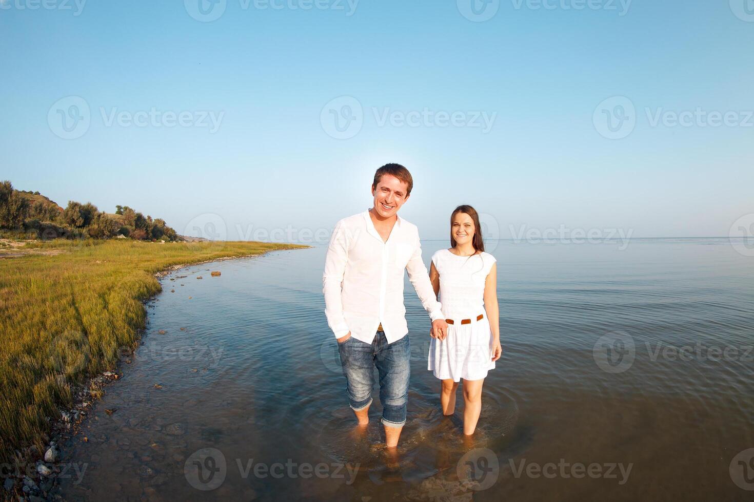 Young happy couple in love by the sea in summer day photo
