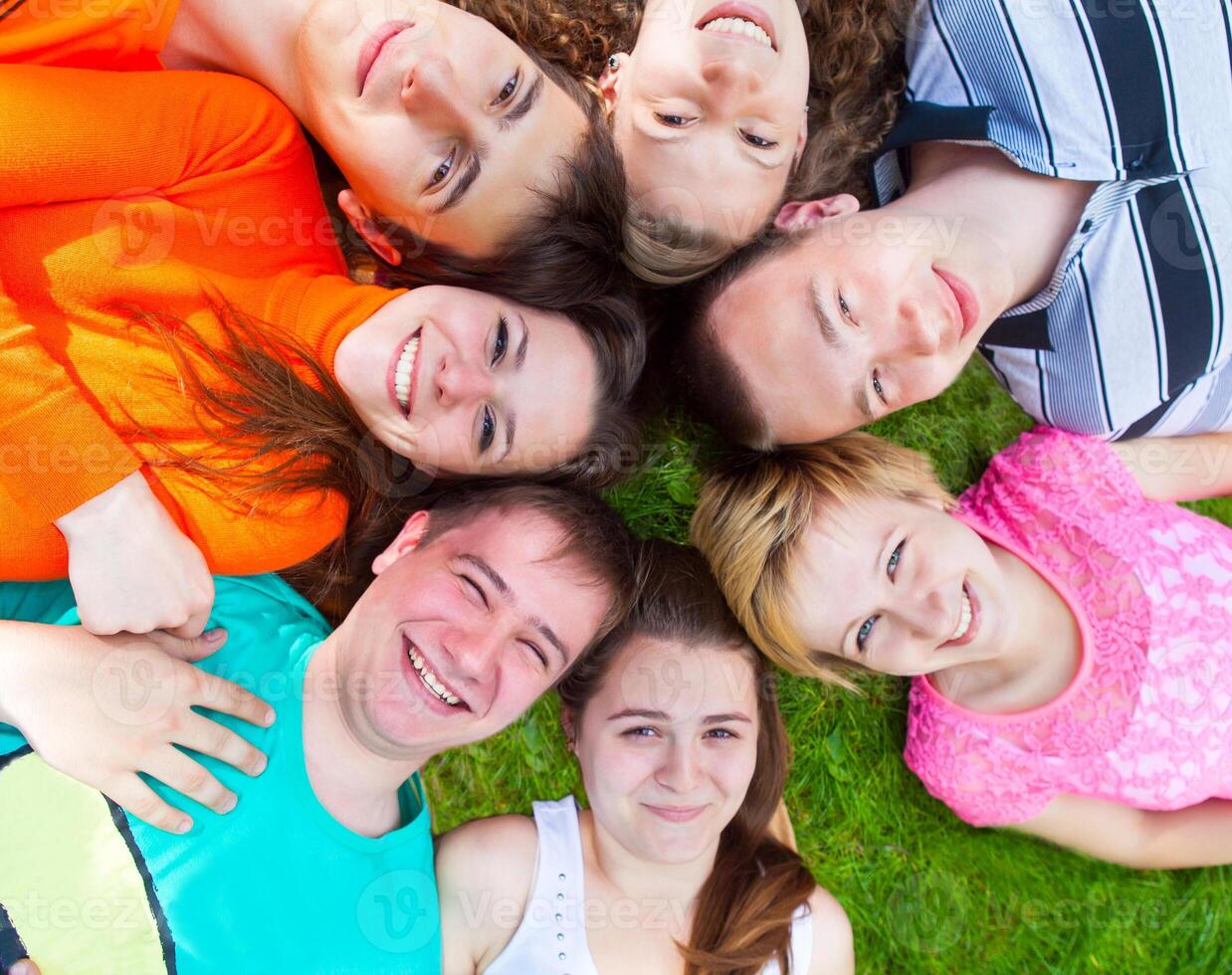 Diverse group of friends outside lying on a lawn photo