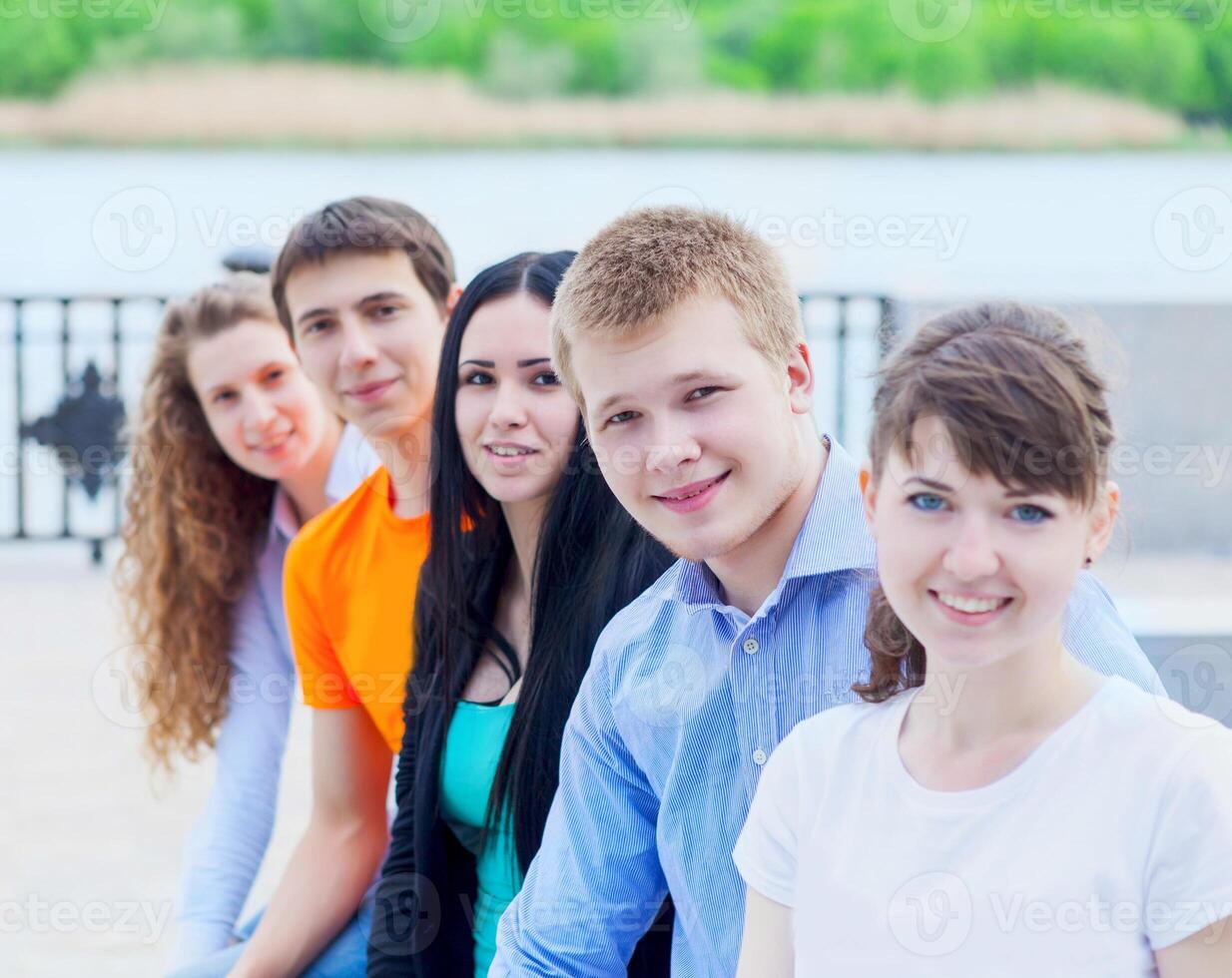 Group of smiling teenagers outdoors, students photo