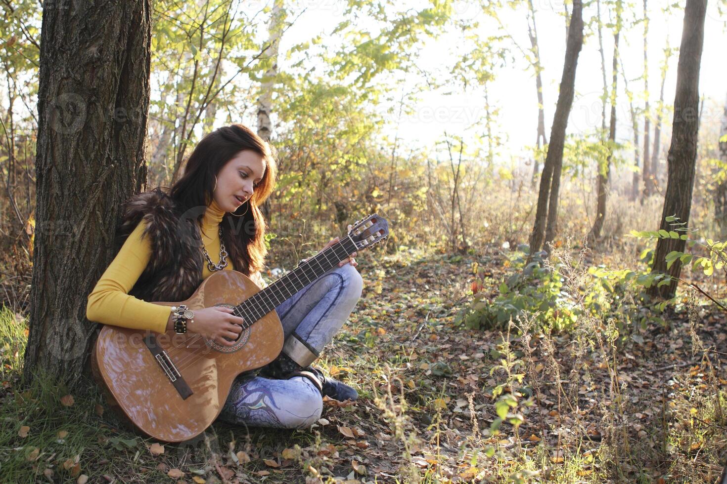 A Guitar player girl outdoors photo
