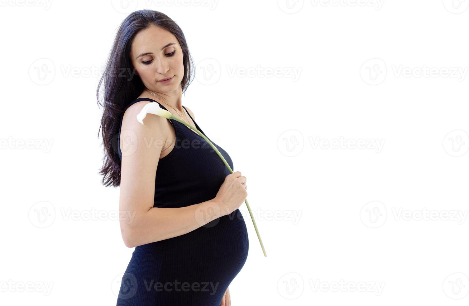 Portrait of an attractive young pregnant woman in a black dress with a flower. A charming expectant mother holds calla lilies. photo