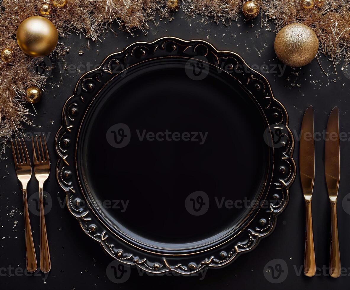 A black plate with a gold rim sits on a table with a fork, knife, and spoon photo