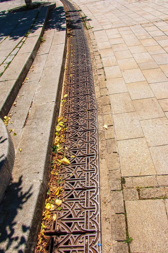 Close-up iron grate drainage system for draining rainwater. photo