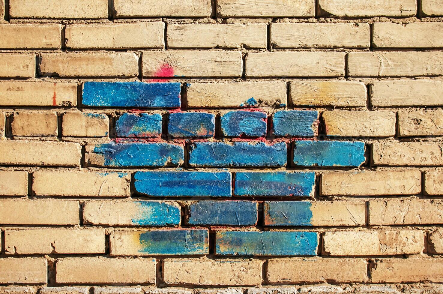 Texture of old colored bricks. Close-up of a red and green brick wall with painted bricks. Horizontal background with free space for text photo